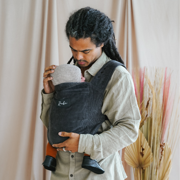 Papa stylé portant bébé dans son Porte-bébé ROOKIE Premium en velour côtelé couleur charbon