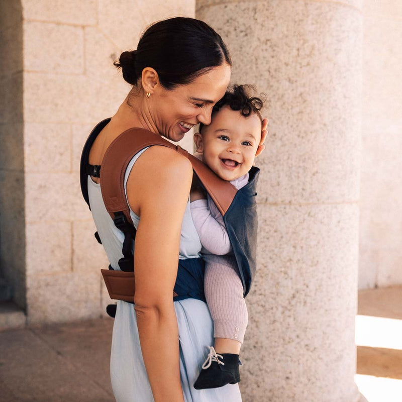 Maman en extérieur avec son porte-bébé physiologique Rookie Revolution bleu marine