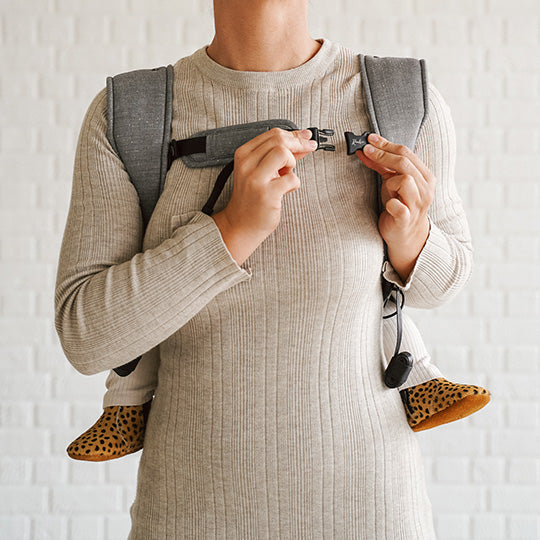 Maman de profil avec son joli porte-bébé en mode dorsal : Rookie Konnekt Gris chiné