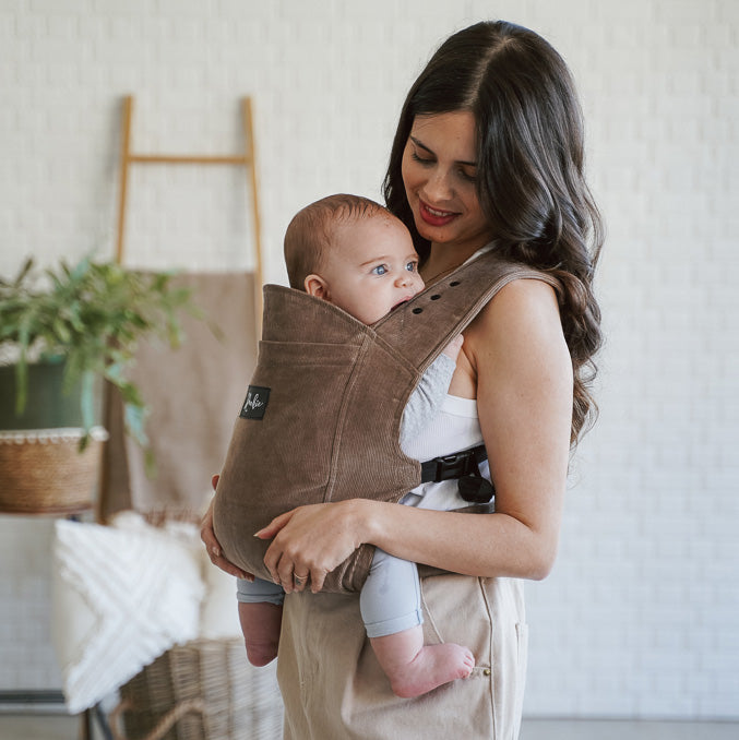 Maman de profil avec son joli porte-bébé physio en velour côtelé bio bio Rookie Premium  Moka