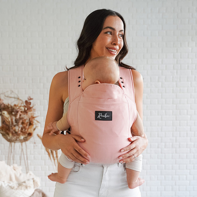 Vue de Face maman portant bébé dans son porte-bébé physiologique Rookie Premium  Rose Pâle