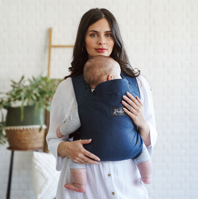Vue de Face maman portant bébé dans son porte-bébé physiologique Rookie Premium  Bleu Marine