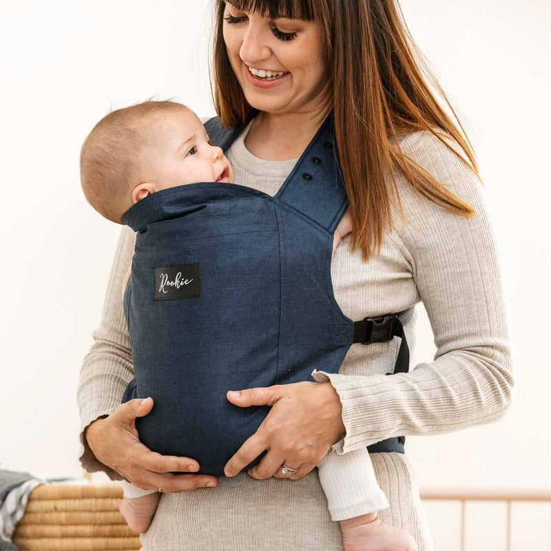 Bébé dans son porte-bébé physiologique Rookie Premium bleu marine