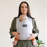 Vue de Face maman portant bébé dans son porte-bébé physiologique Rookie Premium  Gris Clair
