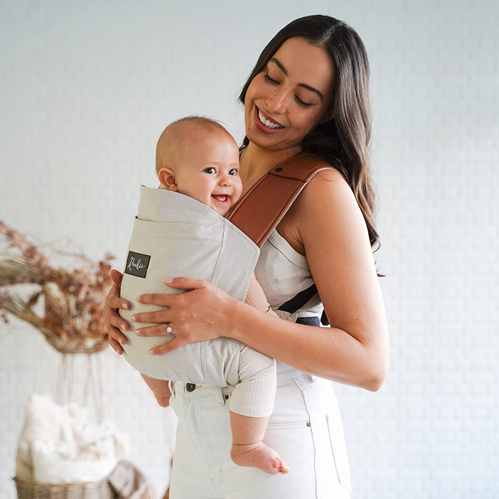 Maman portant bébé dans son porte-bébé physiologique en mode ventral Rookie Revolution - Bleu Marine/Marron